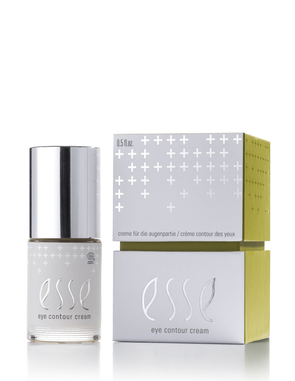 The Esse Eye Contour Cream bottle with a silver cap is shown beside its white and green box, which features minimalist text and plus sign patterns.