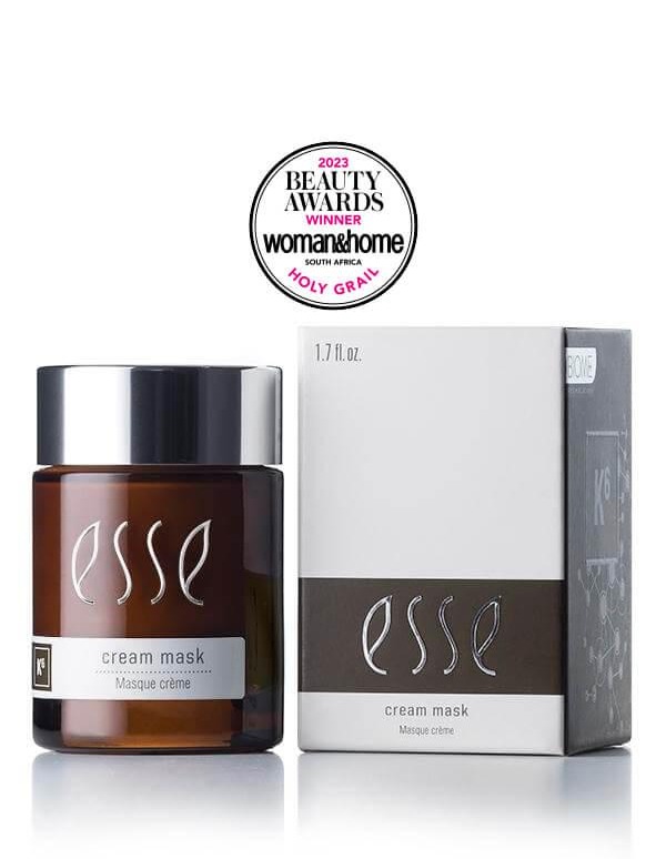 Image of the Award-Winning Esse Cream Mask, a skincare product in a brown jar with a silver cap, placed next to its white and grey box packaging. An award seal above proudly displays "Beauty Awards Winner 2023" by Woman & Home South Africa with "Holy Grail" mentioned below.
